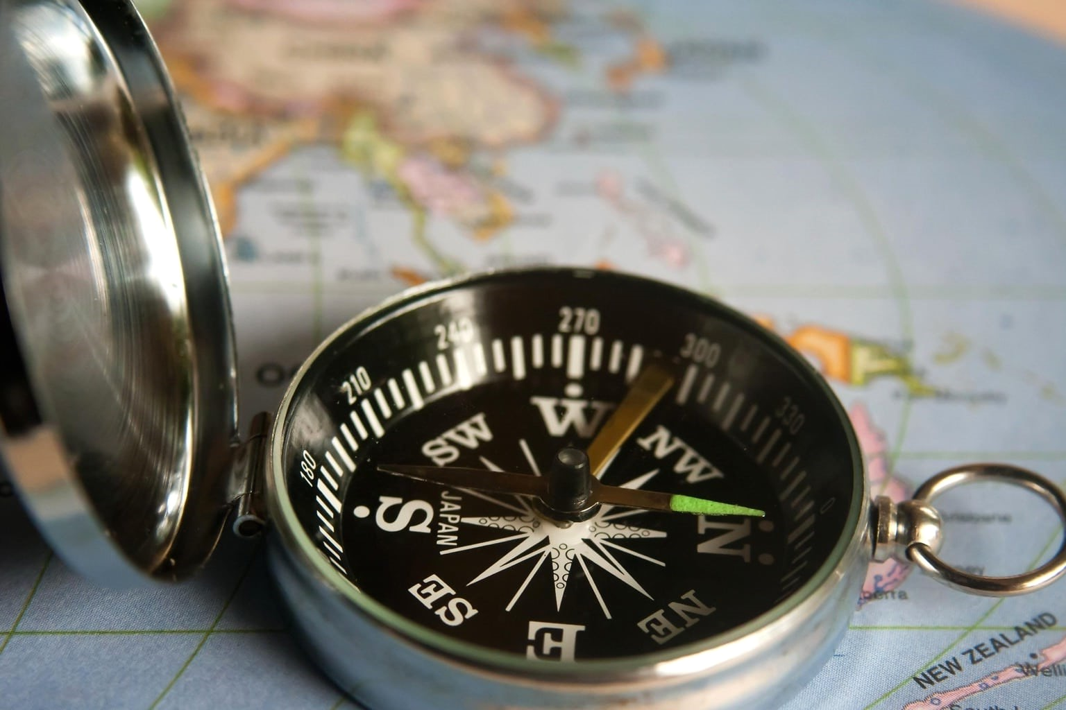 A photo of a compass sitting on a world map